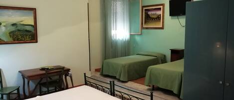 Hotelkamer met twee bedden, een bureau, een stoel, een kledingkast en een plafondlamp.