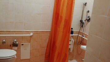 Un baño con inodoro, ducha y toallero.