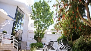 Un edificio moderno con fachada blanca, puerta de vidrio y escalera también blanca.