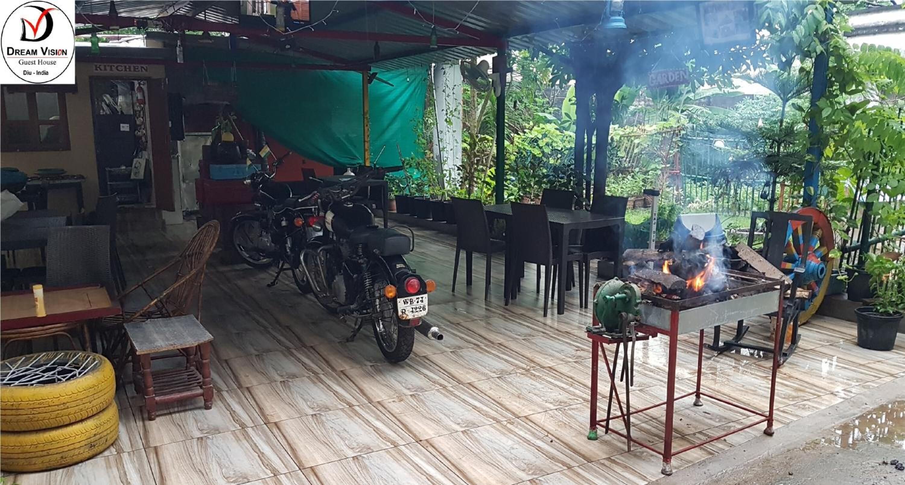 A guest house with a kitchen area, outdoor seating, and a barbecue setup.