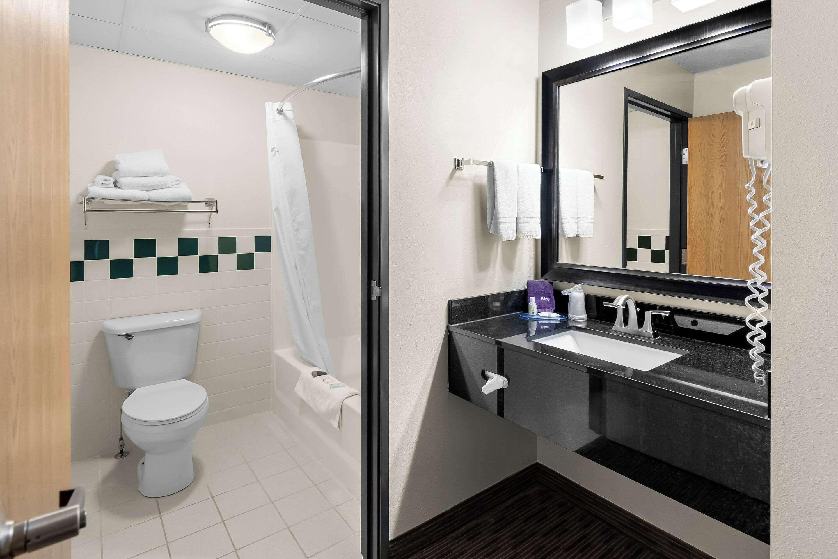 A modern bathroom with a toilet, shower, and sink.