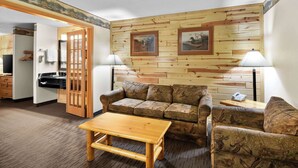 Una habitación acogedora con una pared de madera, un sofá, una mesa y una lámpara.