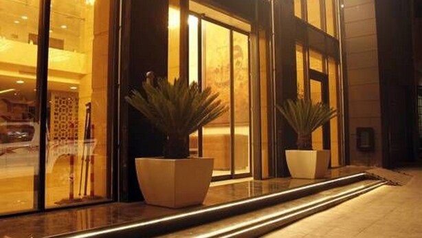 A modern building facade with large windows and potted plants in the entrance area. - Sofi Hotel (Oran)