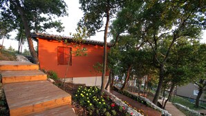 Un pequeño edificio con techo rojo y escalones de madera que llevan hasta la entrada.