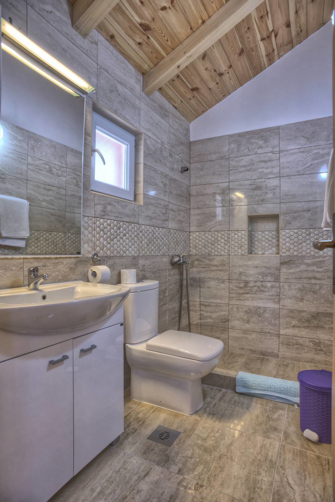 A modern bathroom with a sink, toilet, and shower.
