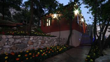 Una casa moderna con un muro de piedra y coloridos jardines florales.