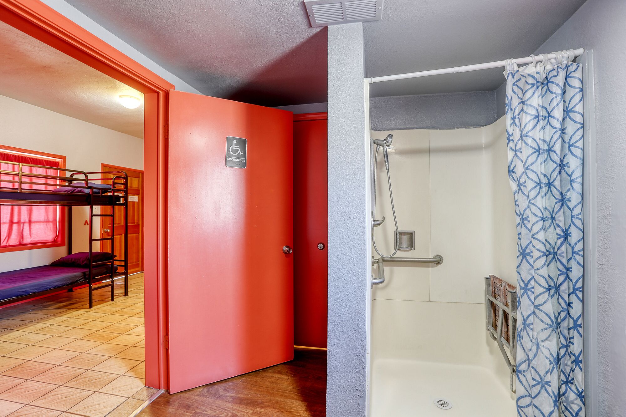 A room with bunk beds, a shower, and a door marked "accessible".