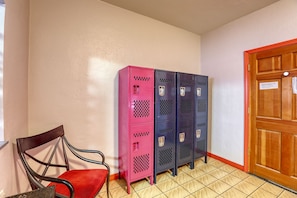 A hallway with lockers, a chair, and a door. - Sin City Hostel Las Vegas (Las Vegas)
