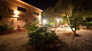 A brick building with a well-lit entrance and a small outdoor seating area. - La Floridita Puerto Piramides (Puerto Pirámides)
