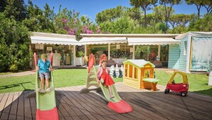 A playground with two slides, a small playhouse, and a toy car. - Forte Village Resort Villa Del Parco & Spa (Pula)