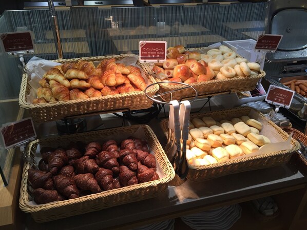 A bakery display with various types of bread and pastries.