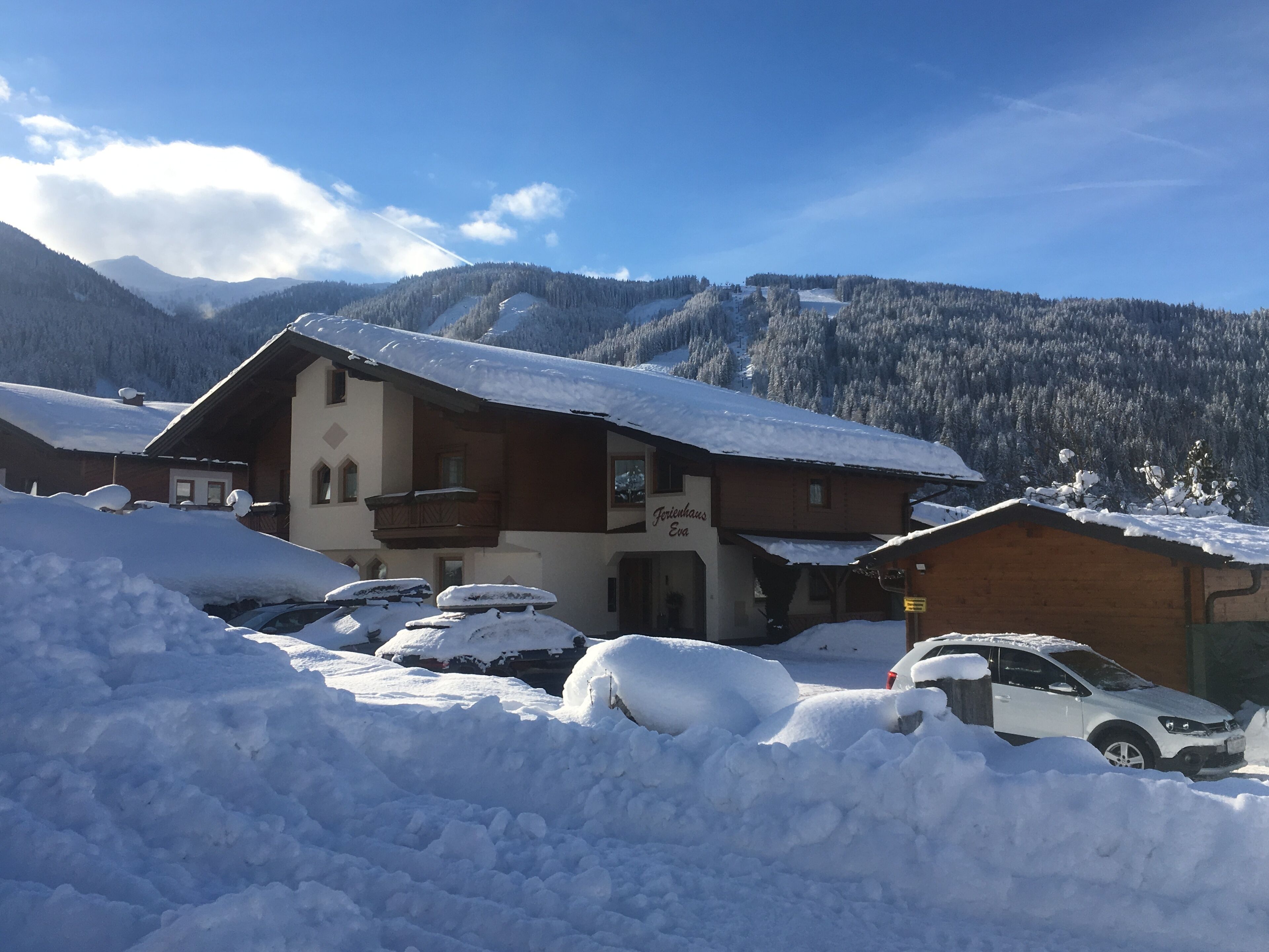 A chalet with a snow-covered roof and a sign reading "Jorlihaus Eva".