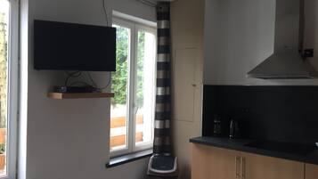 A modern kitchen with a built-in oven, a microwave, and a stove. There is a window with a view of greenery outside.