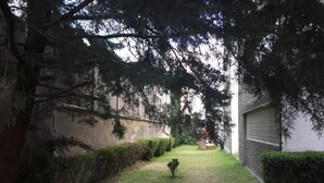 A courtyard with a small lawn, a climbing frame, and a wall with a window. - Departamento en Centro de Toluca (Toluca)