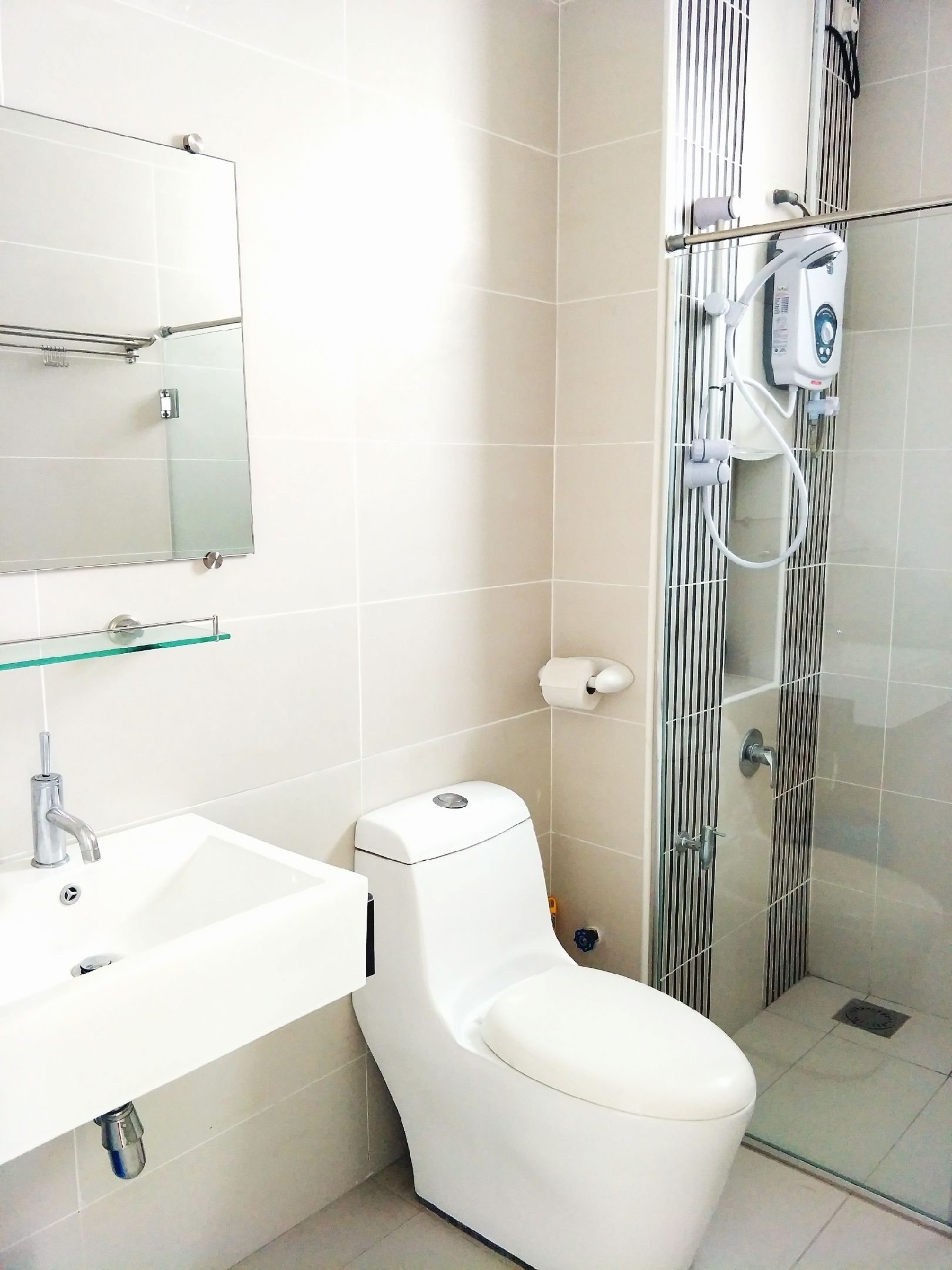 Uma casa de banho moderna com lavatório branco, sanita e cabine de duche em vidro.