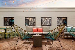 A modern outdoor seating area with a sofa, two chairs, and a coffee table.