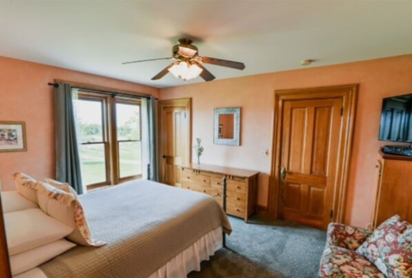 Quarto com cama, penteadeira, escrivaninha e cadeira.
