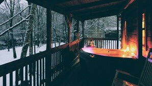 A wooden cabin with a balcony overlooking a snowy forest. - Linville River Log Cabins (Newland)