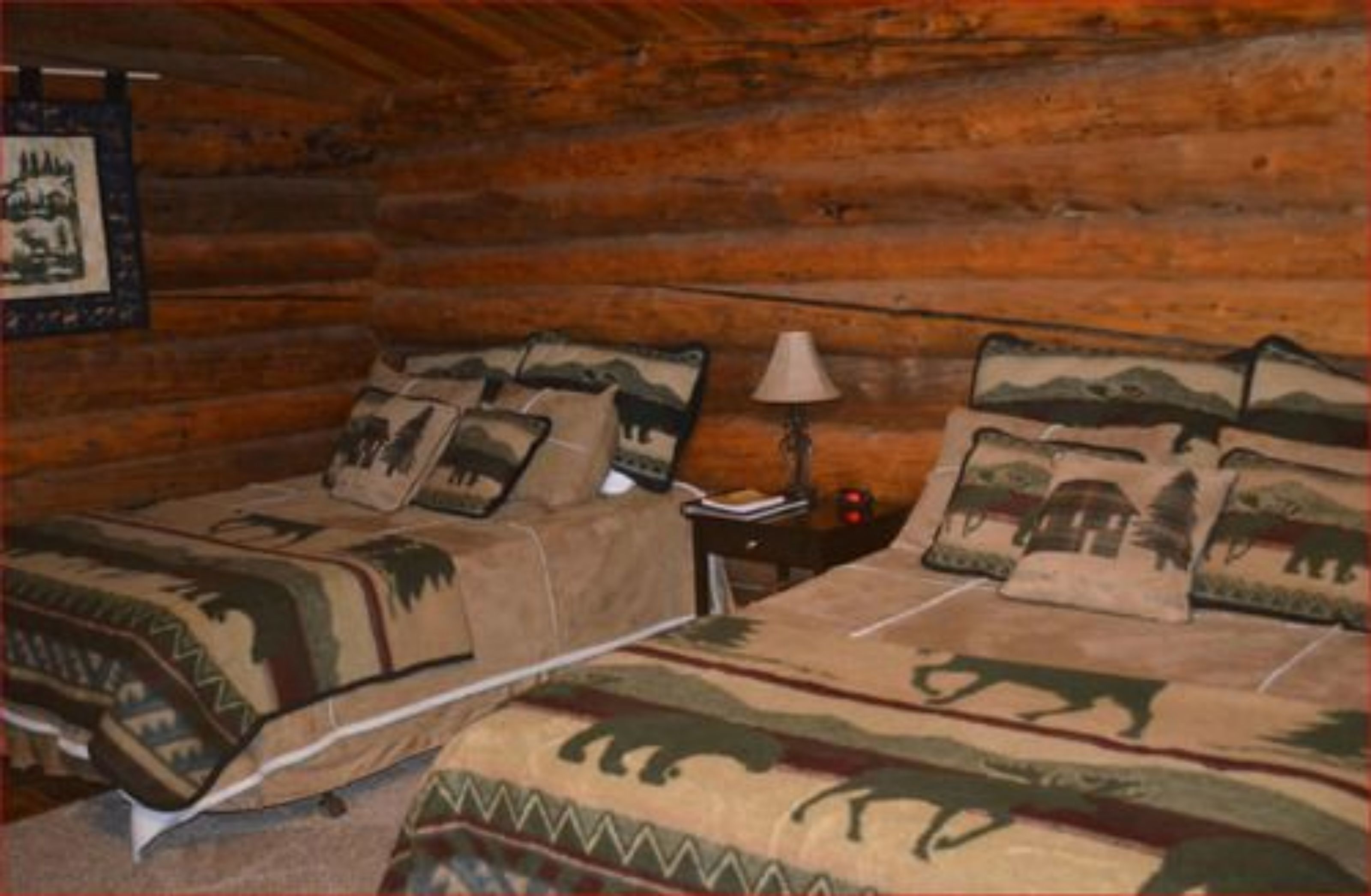 A log cabin room with two beds, each with animal-themed bedding.