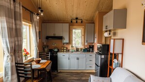 Een gezellige keuken met houten kastjes, een eettafel en een bank.