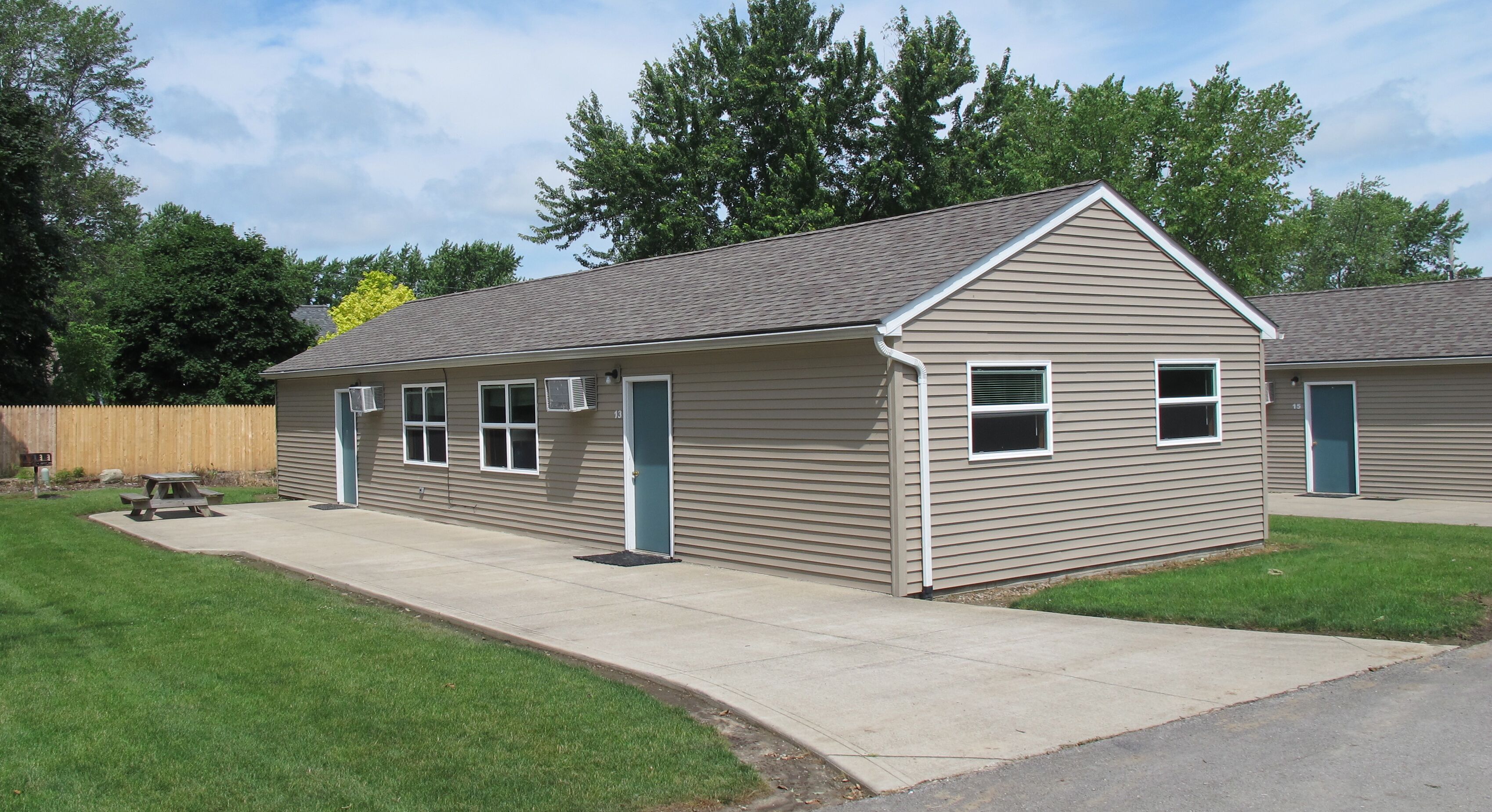 A single-story residential building with a gabled roof, a front door, and a small attached garage.