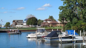Un port de plaisance avec des bateaux amarrés, un quai et des immeubles d’habitation en arrière-plan.