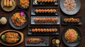 Diverse gerechten, waaronder sushi, sashimi en rijstkommen, gepresenteerd op meerdere borden.