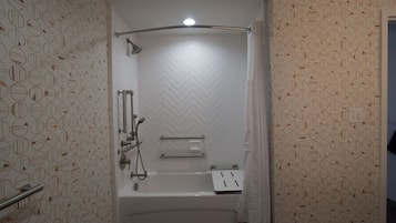A bathroom with a shower, a bathtub, and a towel rack.