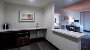 A hotel room with a kitchenette, a bed, a desk, and a TV. - Holiday Inn Lexington - Hamburg by IHG (Lexington)