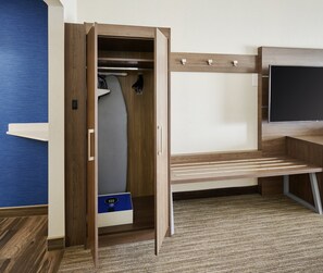 A room with a wooden desk, a built-in wardrobe with a mirror, and a small storage unit with a lock. - Holiday Inn Express and Suites Brantford by IHG (Brantford)