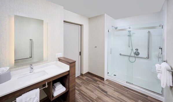 A modern bathroom with a glass-enclosed shower, a white sink, and a wooden vanity. - Holiday Inn Express and Suites Brantford by IHG (Brantford)