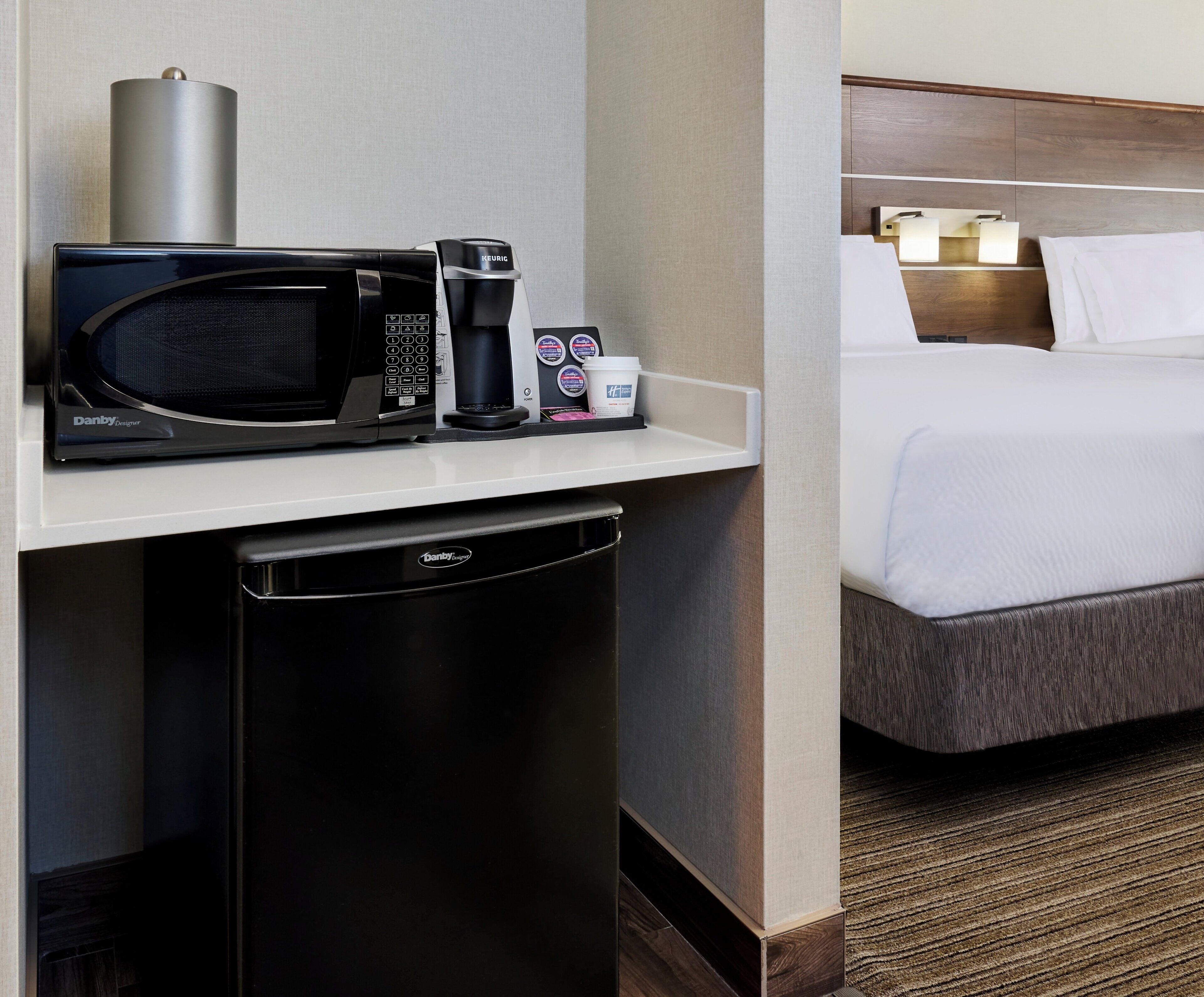 A compact kitchenette with a microwave, coffee maker, and a small refrigerator.