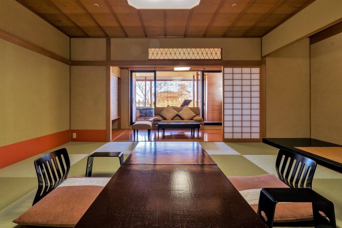 A traditional Japanese room with tatami flooring, a low table, and a sofa.