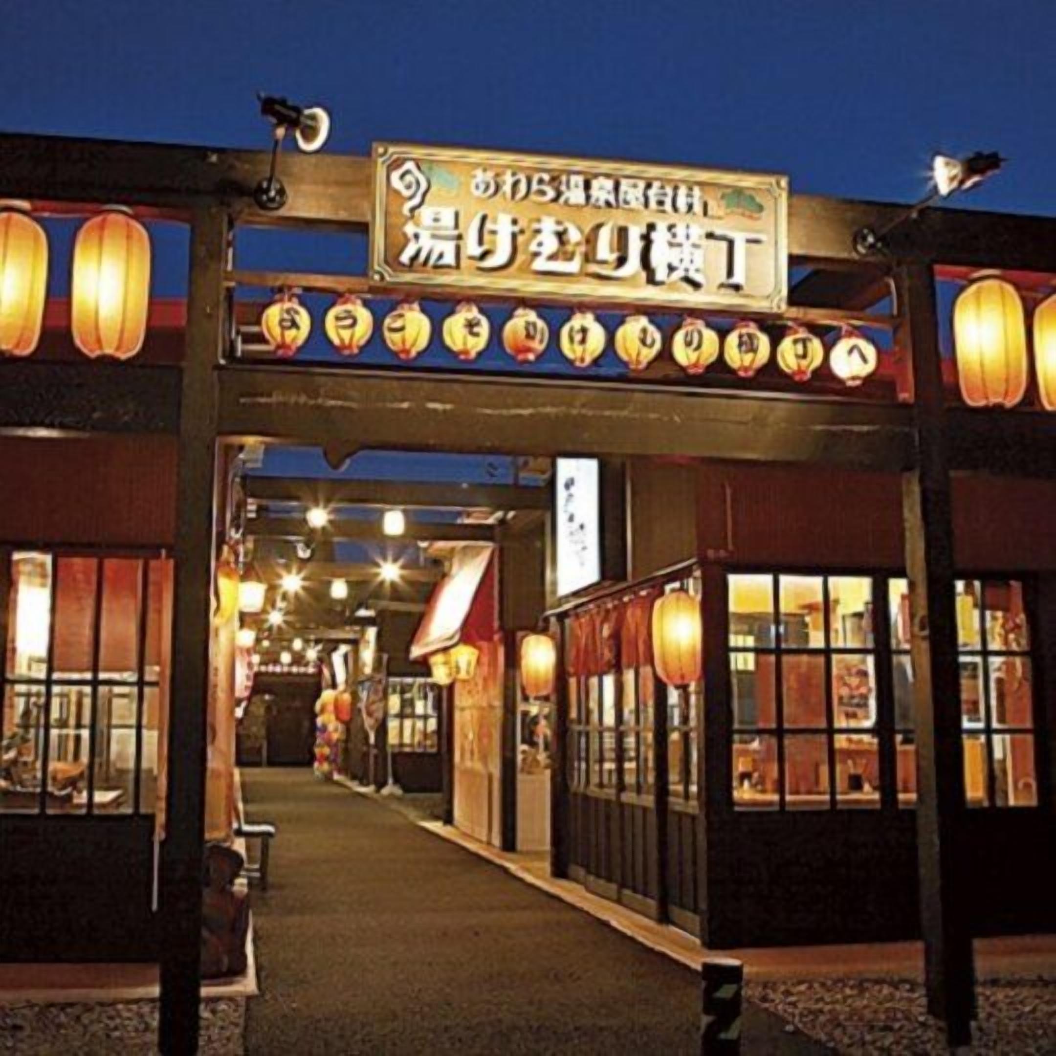 A traditional Japanese restaurant with a signboard and lanterns.