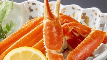 A bowl of crab legs with lemon and parsley garnish.
