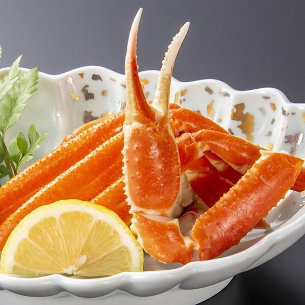 Un plato de patas de cangrejo con adorno de limón y perejil.
