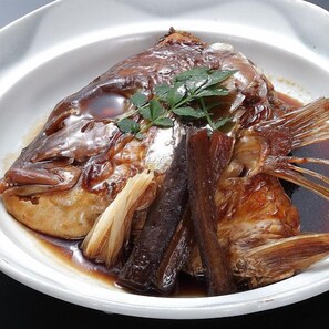 Un plat composé de poisson, d’herbes et de sauce.
