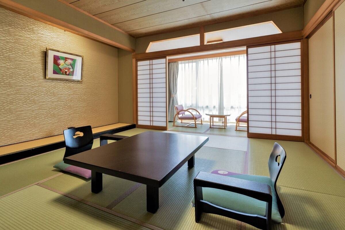 A traditional Japanese room with tatami flooring, a low table, and shoji screens.