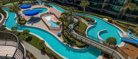 A resort with a large pool area, a water slide, and a view of the sea.