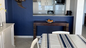 A modern kitchen with white cabinets, a stainless steel refrigerator, and a microwave.
