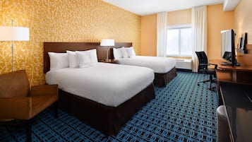A hotel room with two beds, a desk, a chair, a lamp, and a large window.