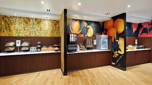 Una zona de recepción con mostrador de madera, máquina de café y refrigerador.
