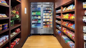 Pasillo con bebidas refrigeradas y una variedad de aperitivos envasados.