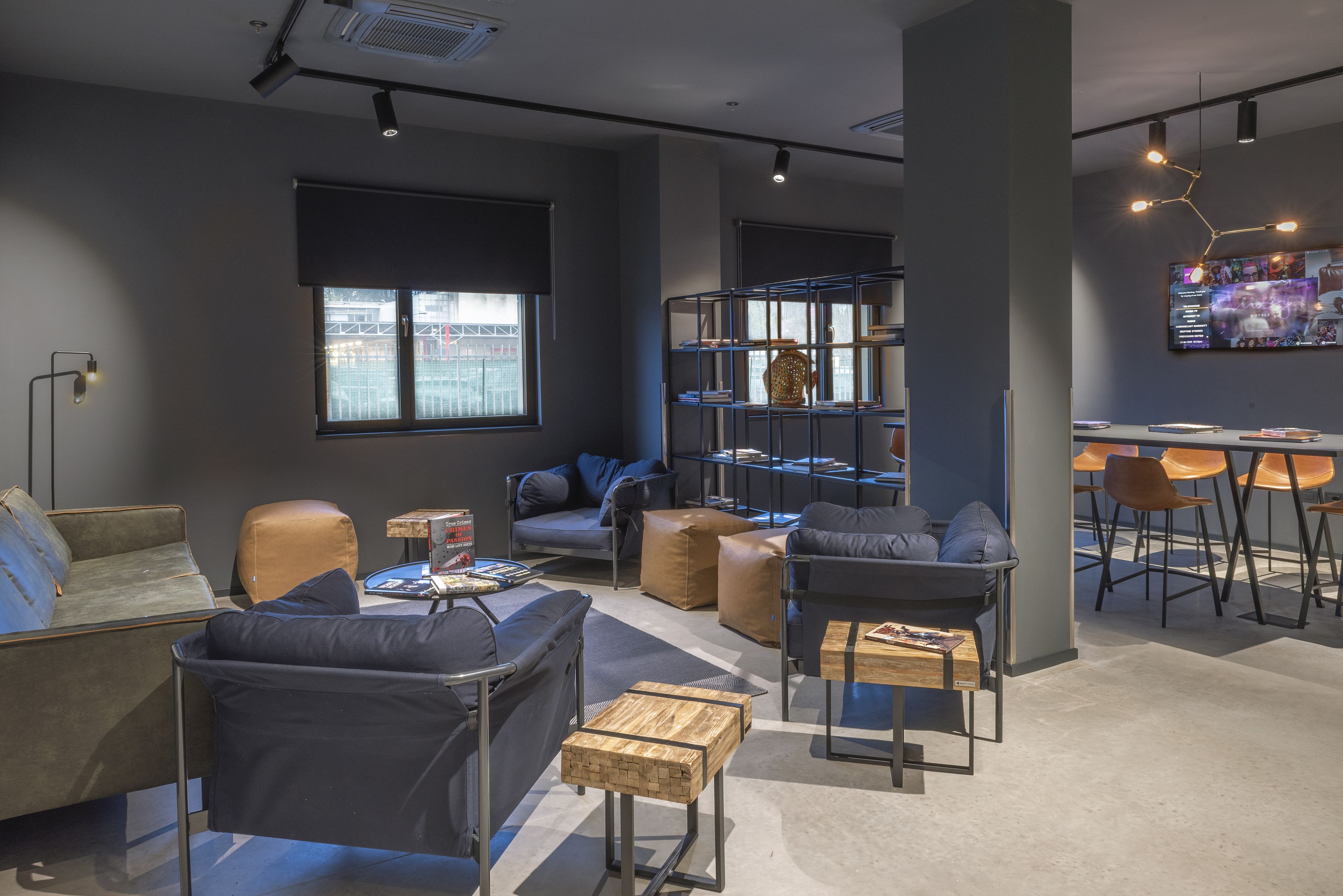 Ein stilvoller Lounge-Bereich mit Sofas, Tischen und einem Bücherregal.