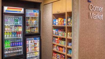 Een buurtwinkel met gekoelde drankautomaten en schappen vol snacks en levensmiddelen.