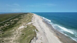 A coastal road with a beach and ocean. - OBX Beach House + Bikes-Paddle Boards-Kayaks-Beach Chairs-Great Fishing! (Rodanthe)