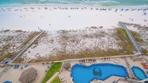 A beach view with a swimming pool and beach umbrellas. - Phoenix III - 9th floor 3 Bedroom (Orange Beach)