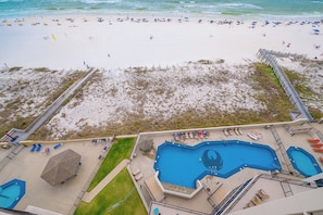 Vista sulla spiaggia con piscina e ombrelloni.