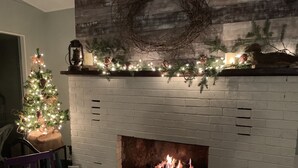 Una chimenea encendida, un árbol de Navidad y decoraciones festivas.