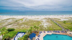 Un complexe hôtelier de bord de mer doté d’une piscine, de chaises longues et offrant une vue sur l’océan.